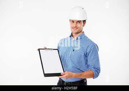 Cheerful young man builder in building helmet holding blank clipboard Stock Photo