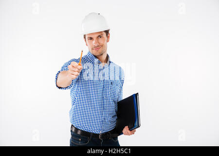 Happy young man architect in hard hat holding folder and pointing on you Stock Photo