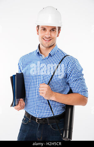 Happy young man building engineer in hard hat holding folders and blueprints Stock Photo