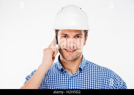 Happy young man building engineer in helmet talking on mobile phone Stock Photo
