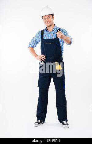Smiling young man foreman in hard hat standing and pointing on you Stock Photo