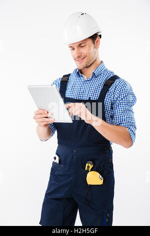 Happy male builder using pc tablet isolated on a white background Stock Photo