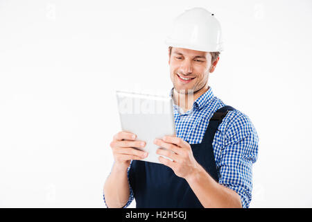 Happy smiling male builder using pc tablet isolated on a white background Stock Photo
