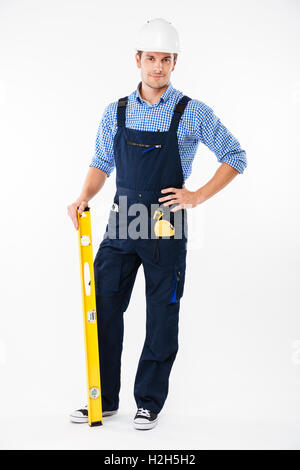 Full length portrait of a smiling male builder standing isolated on a white background Stock Photo