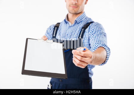 Cropped image of smiling hadsome builder giving blank sheet of paper on clipboard isolated on a white background Stock Photo