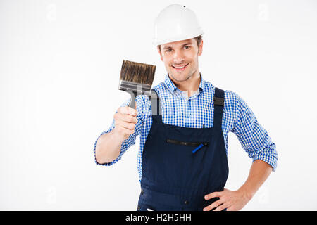 Smiling male painter holding paint brush isolated on a white background Stock Photo