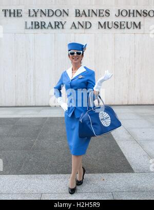 A woman dresses as a 1960s Pan Am flight attendant in a retro and iconic blue stewardess outfit complete with vintage Pan Am bowling bag during the Beatles-inspired Halloween Costume Party at the LBJ Presidential Library October 29, 2015 in Austin, Texas. Stock Photo