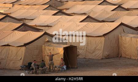 U.S. Air Force soldiers sit outside Tent City, a base made up of hundreds of tents that will house U.S. soldiers deployed in support of Operating Enduring Freedom September 26, 2001 in an undisclosed location in Kuwait. Stock Photo