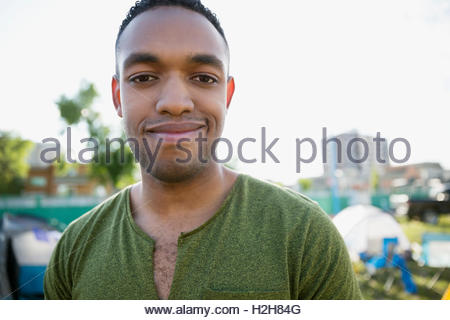 Portrait smiling young man at summer music festival campsite