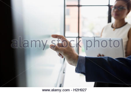 Close up businessman using touch screen television in conference room
