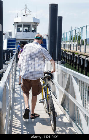 New York City,NY NYC,Brooklyn,Brooklyn Bridge Park Pier 6,Yankee Pier,Governors Island Ferry,boat,adult,adults,man men male,bicycle bicycles bicycling Stock Photo