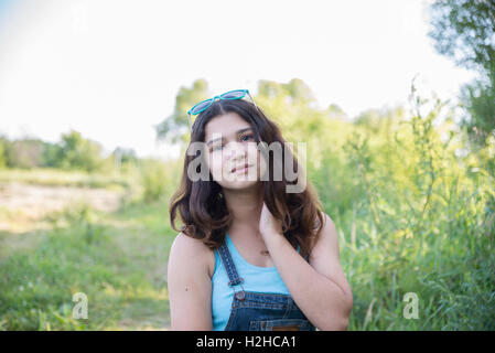 Girl with sunglasses on her head posing in nature Stock Photo