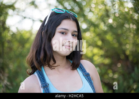 Girl with sunglasses on her head posing in nature Stock Photo