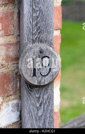The number 19 attached to a brick wall. Stock Photo