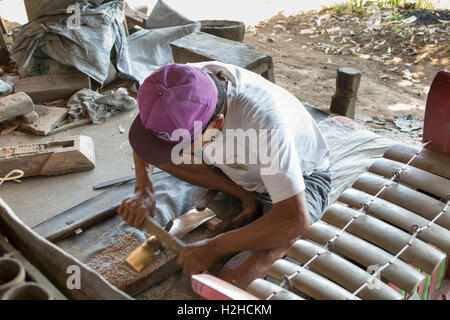 Indonesia, Bali, Sawan, man making gamelan gongs in small traditional workshop Stock Photo