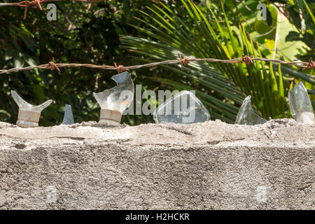 Indonesia, Bali, Lovina, home security, broken glass and barbed wire above house wall Stock Photo
