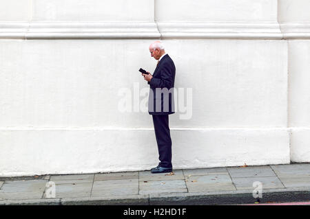 London, England,UK. Older man using his mobile phone, at Hyde Park Corner Stock Photo