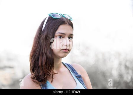 Girl with sunglasses on her head posing in nature, toned image Stock Photo