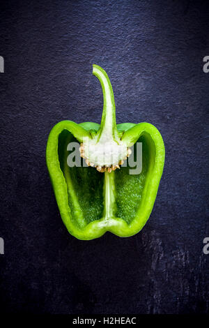 Cross section of a green bell pepper on dark bacground from above Stock Photo