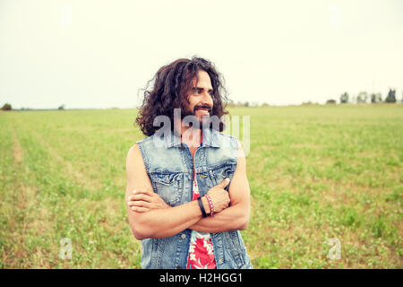 smiling young hippie man on green field Stock Photo