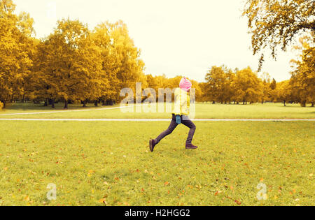 happy little girl running in autumn park Stock Photo