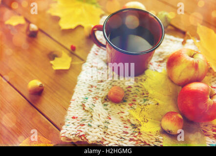close up of tea cup on table with autumn leaves Stock Photo