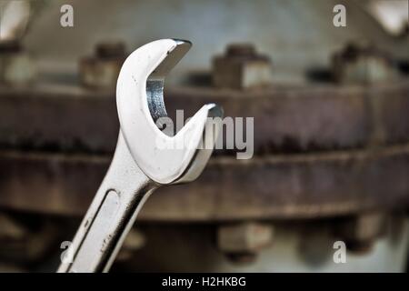 Shining new Wrench on a rusty bolt Stock Photo