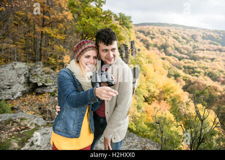 Young couple on a walk in sunny autumn forest Stock Photo