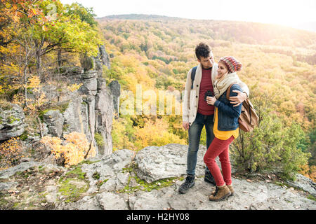Young couple on a walk in sunny autumn forest Stock Photo