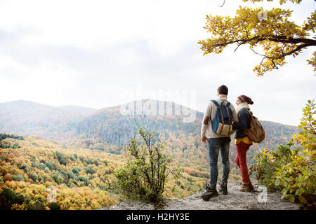 Beautiful couple with backpacks against colorful autumn forest Stock Photo