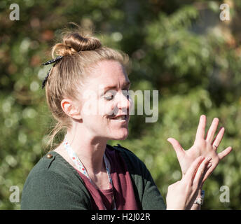 Female signer using sign language for people with impaired hearing at UK festival. Stock Photo