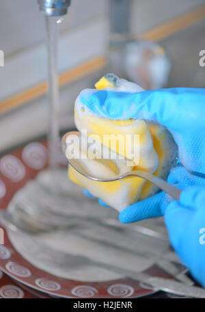 Woman hand washing dishes in the kitchen Stock Photo