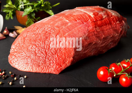 Still life raw beef round over black ground Stock Photo