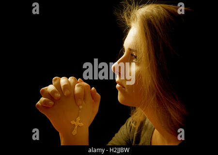 Catholic girl praying with a rosary Stock Photo - Alamy