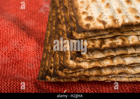 Matzah - jewish passover bread on red burlap Stock Photo