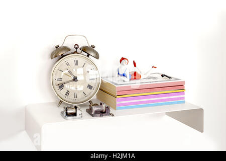 Alarm clock and books on nightstand Stock Photo