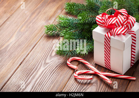 Christmas gift box, candy cane and fir tree branch. View with copy space Stock Photo