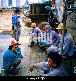 Construction workers having a break at building site, Singapore Stock Photo
