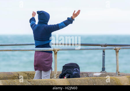 Woman practicing yoga by the sea. Stock Photo