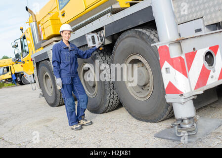 Woman operating controls on side of lorry Stock Photo