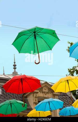 Multi colored umbrellas in blue sky. Rainbow from umbrellas in sky Stock Photo