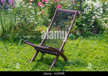 Wooden chair from a set of garden furniture on a green lawn Stock Photo