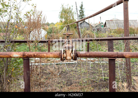 old rusty valve on the of an old rusty pipe Stock Photo