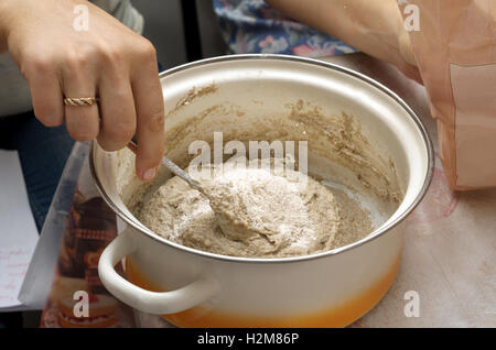 Making sourdough starter. Female hands. Stock Photo