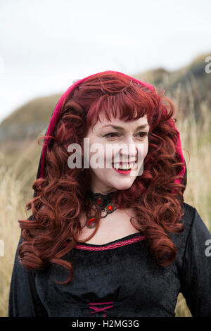 Goth Woman black dress with vampire fangs Stock Photo