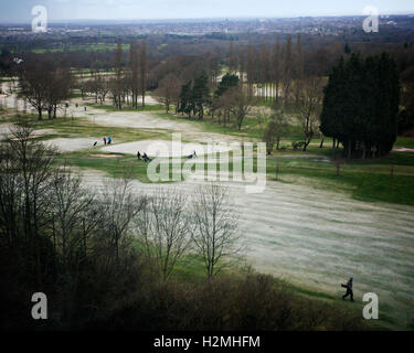 Golfers walking on frosty golf course Stock Photo