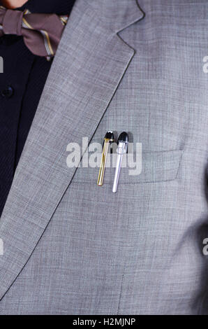 Closeup man's chest area wearing formal suit and bowtie, two pens sticking out from jacket pocket, men getting dressed concept Stock Photo