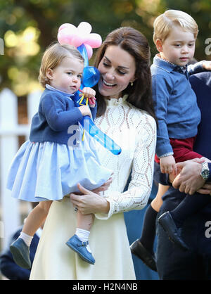 The Duchess of Cambridge holding Princess Charlotte as Prince Prince George looks on at a children's party at a children's party for Military families at Government House in Victoria during the Royal Tour of Canada. Stock Photo