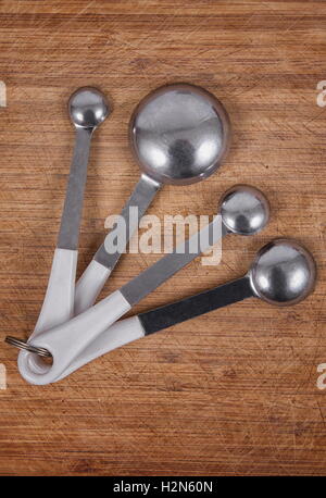 tea spoons over wooden kitchen table Stock Photo