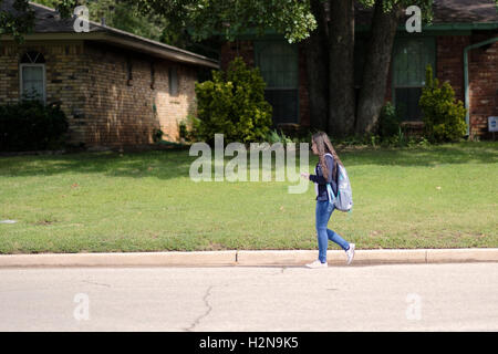 A  14-year-old Caucasian middle-school girl walking home after classes in Oklahoma City, Oklahoma, USA. Stock Photo